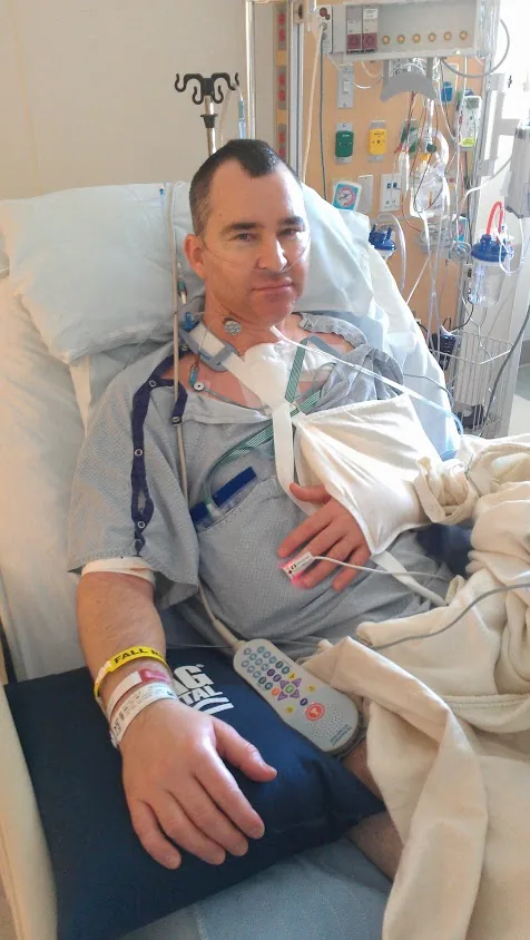 TIG in a hospital bed at Hoag during the weeks after his heart stopped
