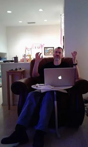Laptop open on the couch, wrestling with the work
