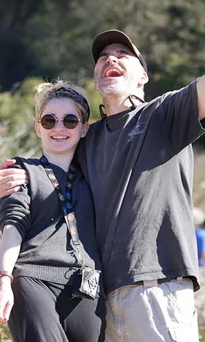 Arm around Annie, both mid-laugh