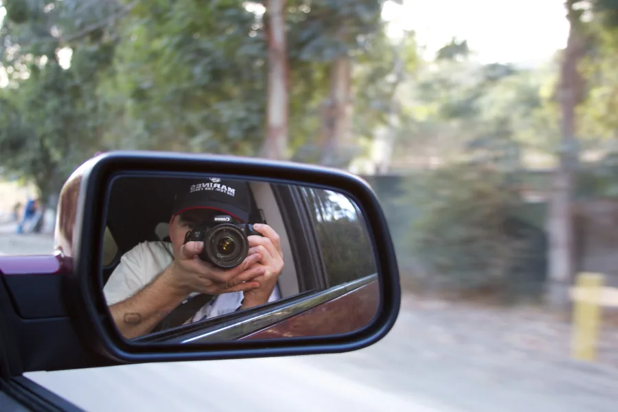 Camera raised, caught in a side mirror