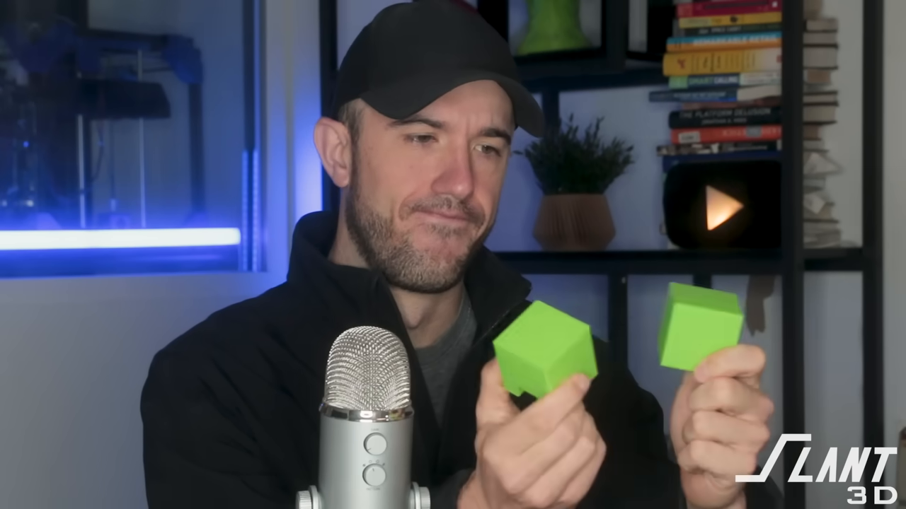 Man demonstrating two green cubes