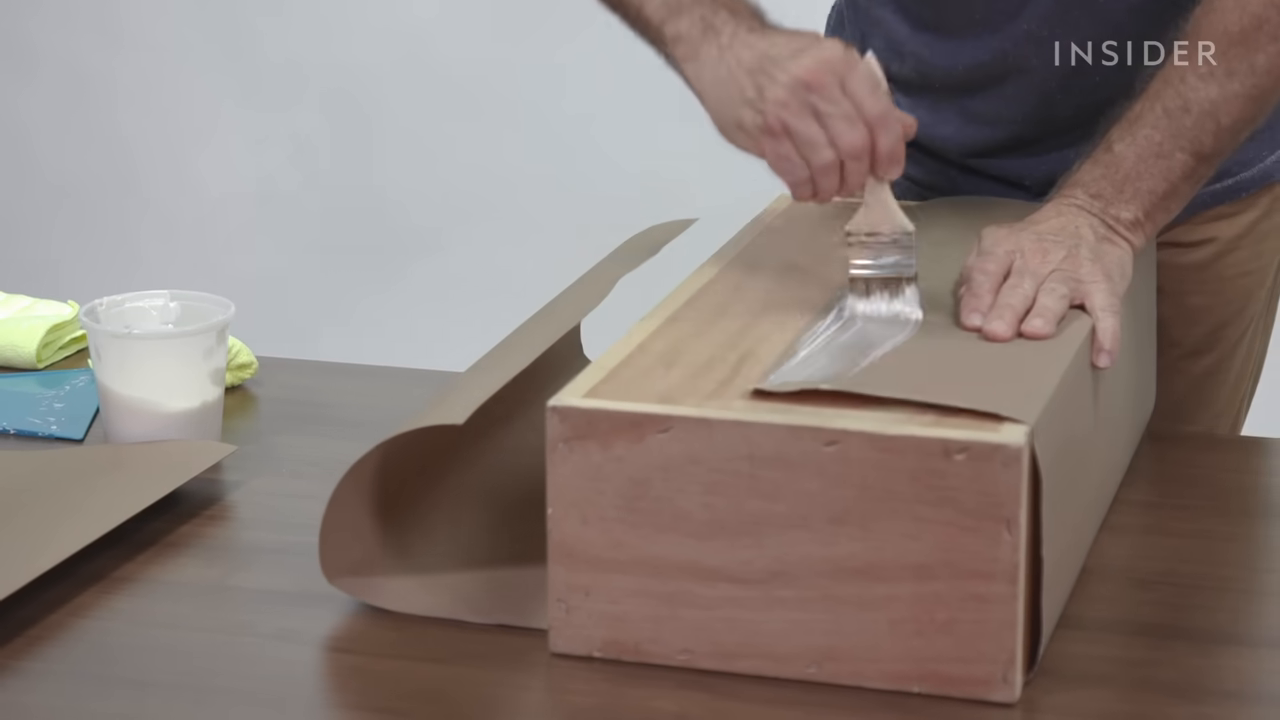 Man glues paper on mold.