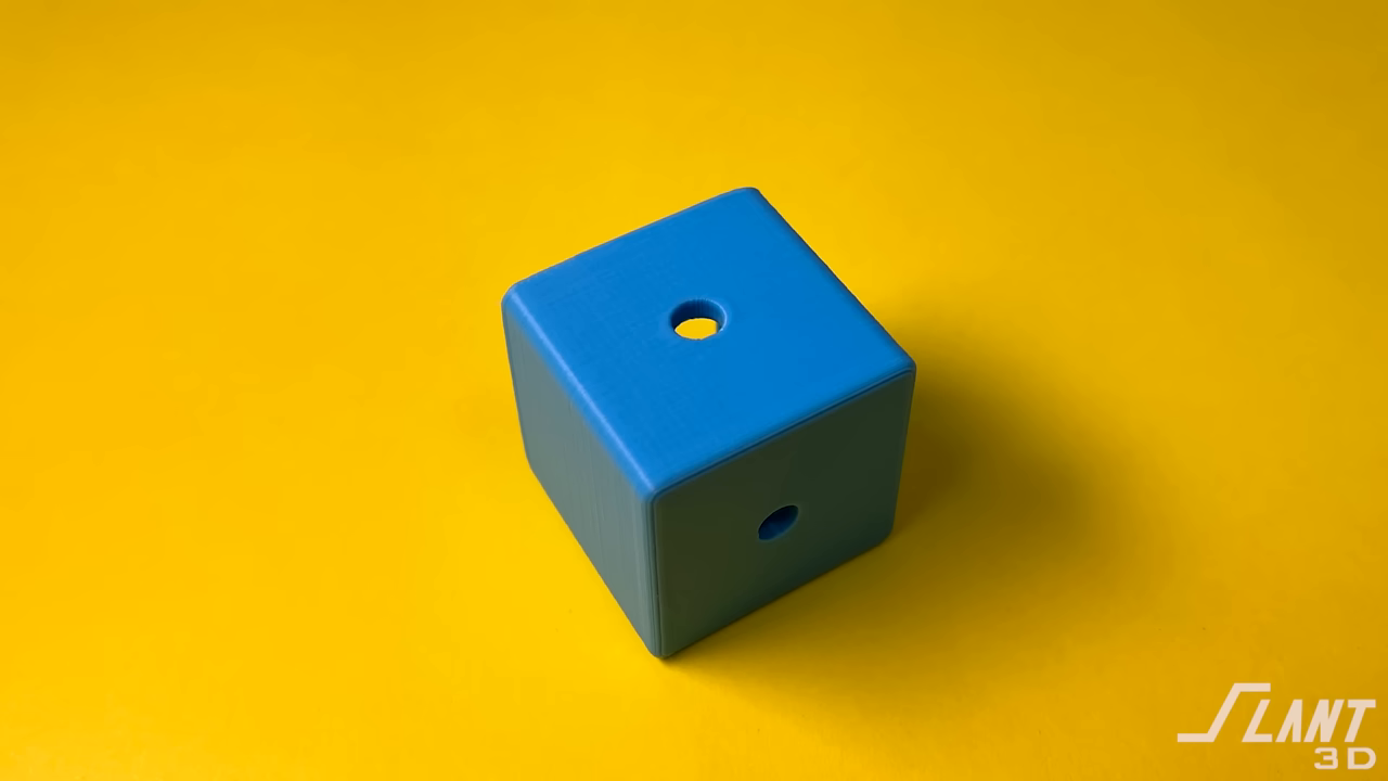 Close-up of a 3D printed blue cube showing slight layer rippling inside a generic side hole.