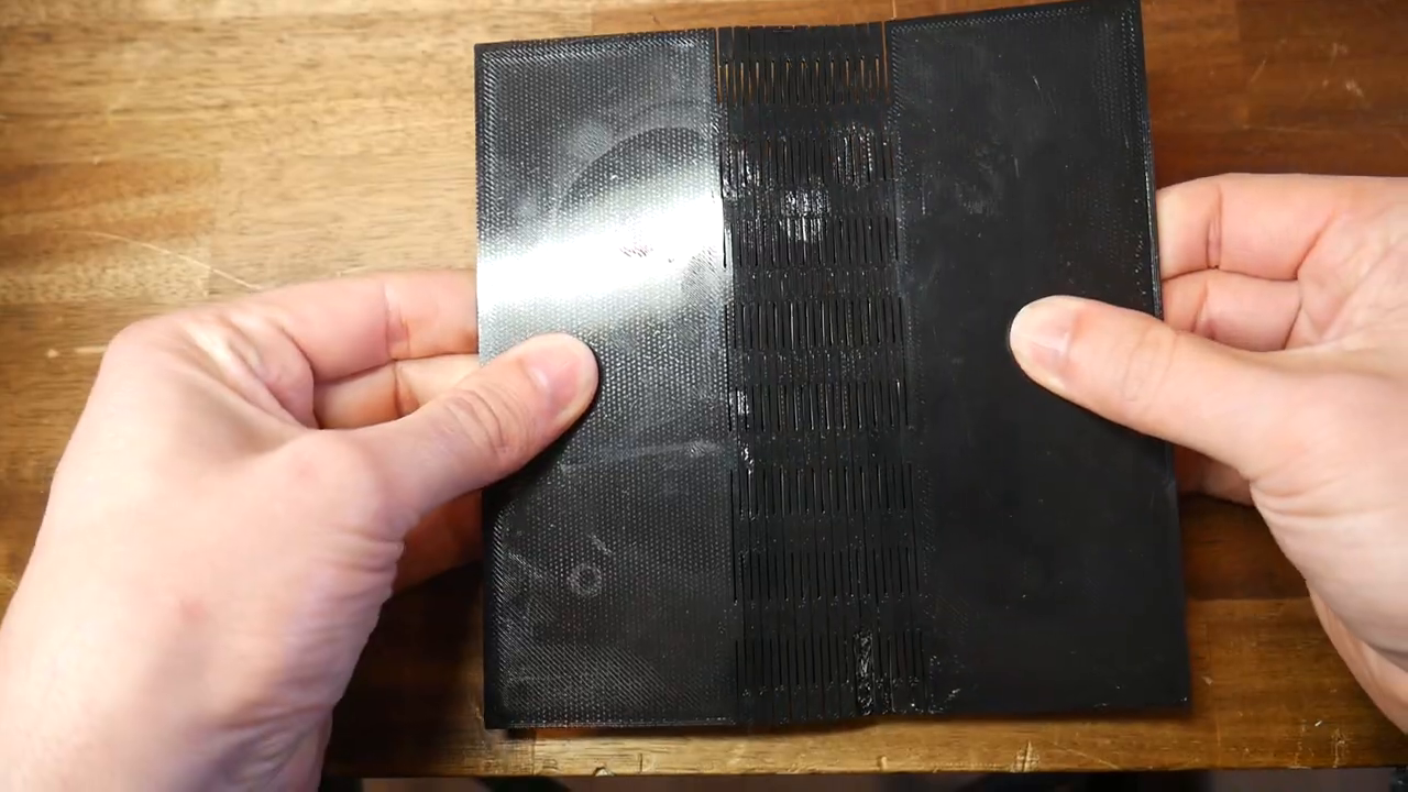 Close-up demonstration of the 3D printed PETG test strip being bent, clearly showing how the slots flex open.
